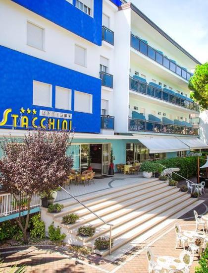 Hotel moderno con terrazza, bandiere e sedie all'aperto.